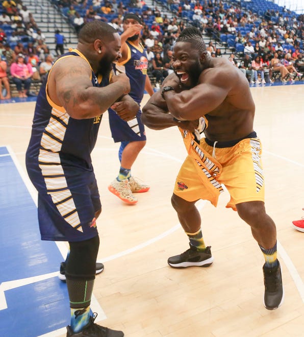 Brian Faucett of Wilmington (left) measures up against body builder Robert Wilmote before player introductions during Duffy's Hope 19th Annual Celebrity Basketball Game at the Chase Fieldhouse in Wilmington, Saturday, August 5, 2023.