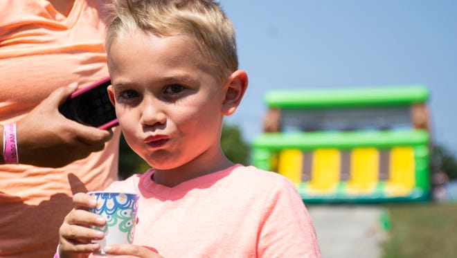 Lucas Witt, 6 years of age, drinks a cup of water at the water station before heading to the next obstacle course at The Great Inflatable Race in Shrewsbury, Pa. on Saturday, July 14,2018. He came with his mom and both are from Frederick Md.