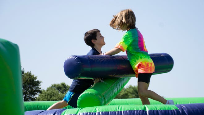 Andrew B., 8 years of age, and Eiley Moos, 10 years of age play a game at The Great Inflatable Race in Shrewsbury, Pa. on Saturday, July 14, 2018.