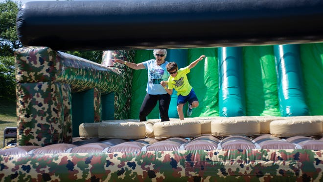 Karen Taylor and her grandson Dylan Taylor, run together through the obstacles course at The Great Inflatable Race in Shrewsbury, Pa. on Saturday, July 14, 2018.