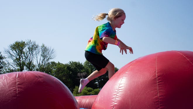 Eva Moos, 6 years of age, from Fallston, Md. jumps through inflatable game at The Great Inflatable Race held in Shrewsbury, Pa. on Saturday, July 14, 2018.