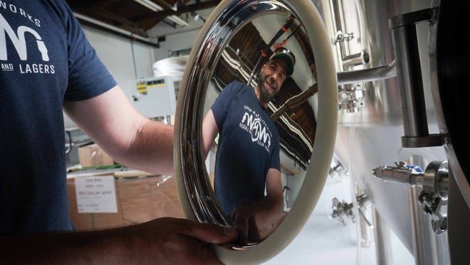 Craig Wensell, CEO and head brewer at Wilmington Brew Works, reflects in a door of a beer tank at his brewery that he plans on opening by the end of June.