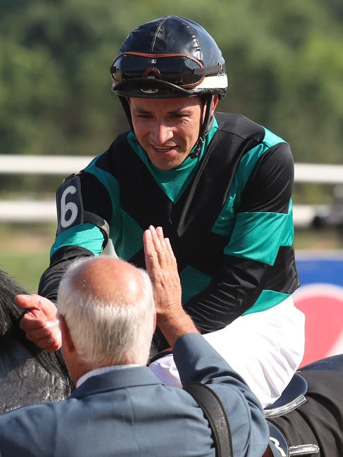 Jairo Rendon is congratulated by trainer Patrick McBurney after winning with Golden Brown in the Kent Stakes Saturday at Delaware Park.