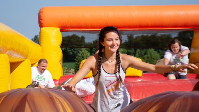 Cassie Zunner goes through the "food coma" inflatable obstacle course during the race held in Shrewsbury, Pa. on Saturday, July 14,2018.