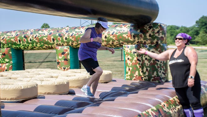 Evelyn Krauth 72, runs through an obstacle course while Melissa Heath 41, cheers her up at The Great Inflatable Race in Shrewsbury, Pa. on Saturday, July 14, 2018.
