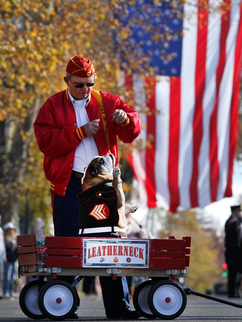 Retired Marine Sgt Ben Warner, Lansdale, PA, coaxes his English Bulldog 'Segeant Leatherneck' to salute during the National Anthem during the Toms River Veterans Day parade Monday, November 14, 2016.