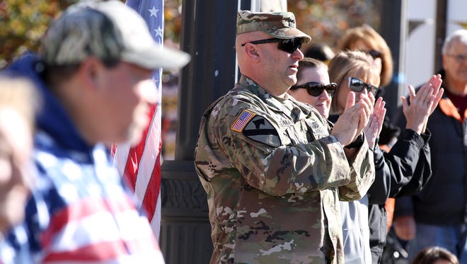 Army Captain Rob Roma, Toms River, applauds along Washington Street during the National Anthem during the Toms River Veterans Day parade Monday, November 14, 2016.  He has served in the National Guard for 20 years.