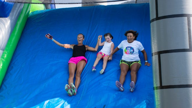 From Left, Jessie Blank, Mille Blank, 5 years of age, and Ms. Chandlee go down the Castle Of Doom at The Great Inflatable Race in Shrewsbury, Pa. on Saturday, July 14,2018. First Time doing the race.