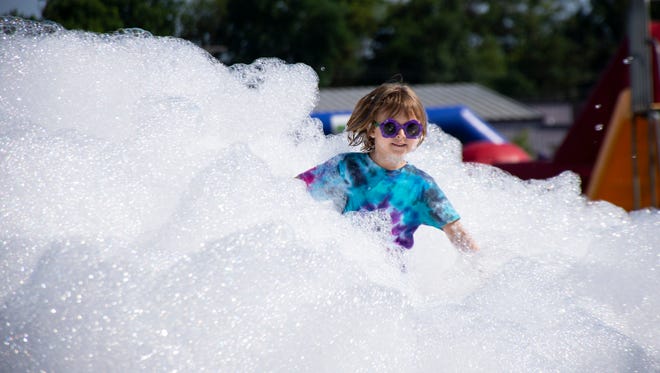 Ava Manry, 6 years of age, runs through the foam bubble at The Great Inflatable Race in Shrewsbury, Pa. on Saturday, July 14, 2018.
