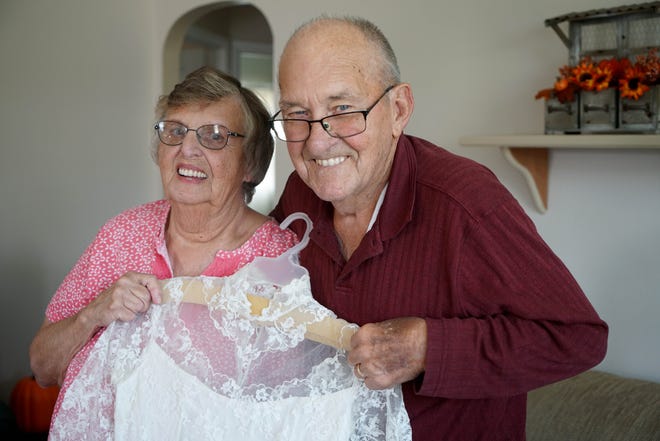 Betty Jean, 81, and Charles, 85, Morrison, hold her 1957 wedding dress. They will remarry Saturday, Sept. 22, because their original license has been lost.