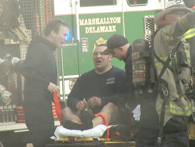 Dave Smiley Jr. (seated on stretcher) was upgraded to fair condition after sustaining burns while battling Thursday's fire in Mill Creek.