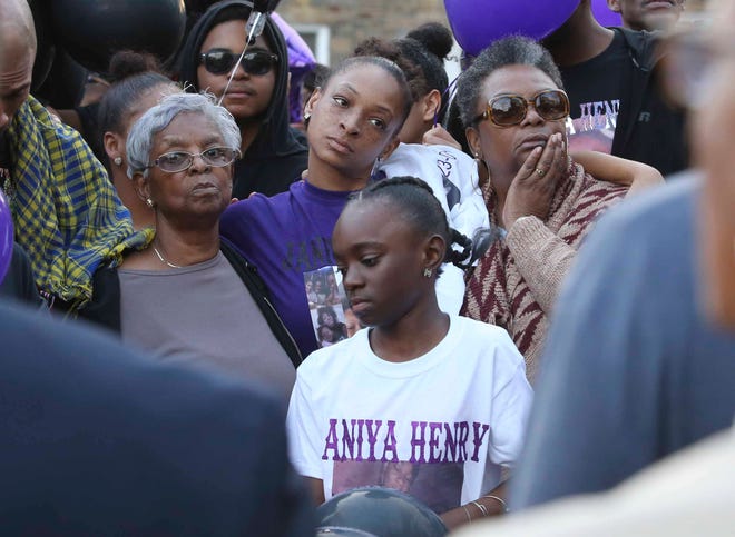 Shavontai Hale (center rear), mother of Janiya Henry, is flanked by her grandmother, Mamie Hale (left) and mother, Sheila Hale and other family members during a memorial gathering for Janiya Henry Friday evening in Wilmington.