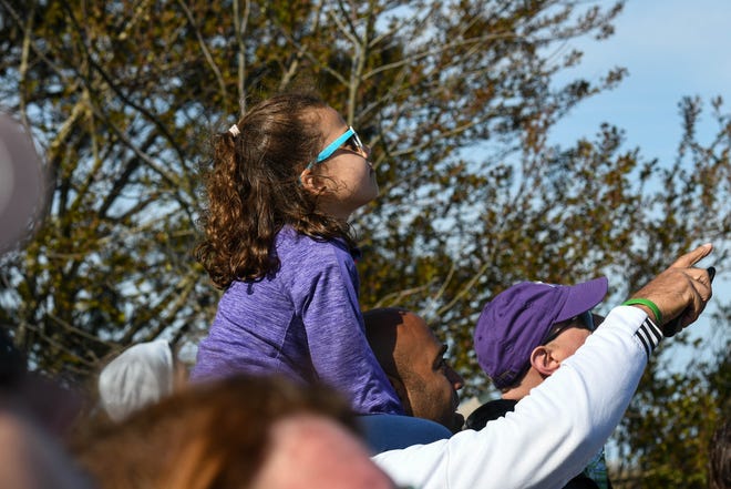5-year-old Zoe Landry stares up at the  NG-11 rocket launch atop her father's shoulders at the NASA Wallops Island visitor's center on Wednesday, April 17, 2019.