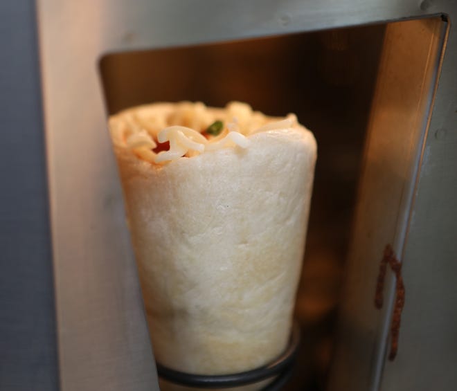A prepared pizza cone gets ready to go into the oven for three minutes.