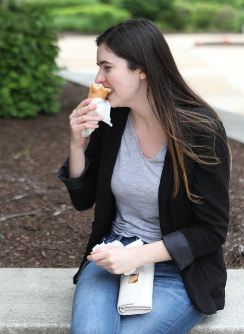 Jackie Mattson sits and eats a pizza cone at the Wilmington Riverfront.