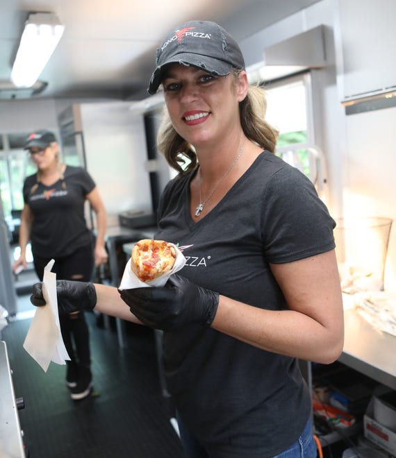 Danielle Sundermeier holds a pizza cone fresh out of the over. Sundermeier got the idea of becoming a franchise after trying the treat in Aruba.