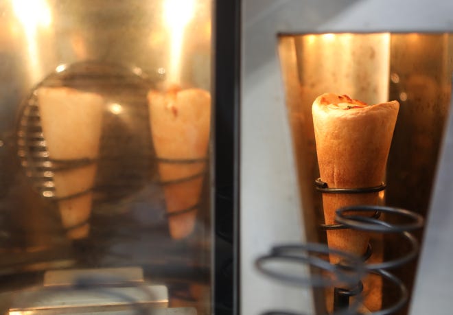 After all the traditional pizza ingredients are stuffed into the cone-shaped dough, the pizza cone goes into an oven for three minutes.
